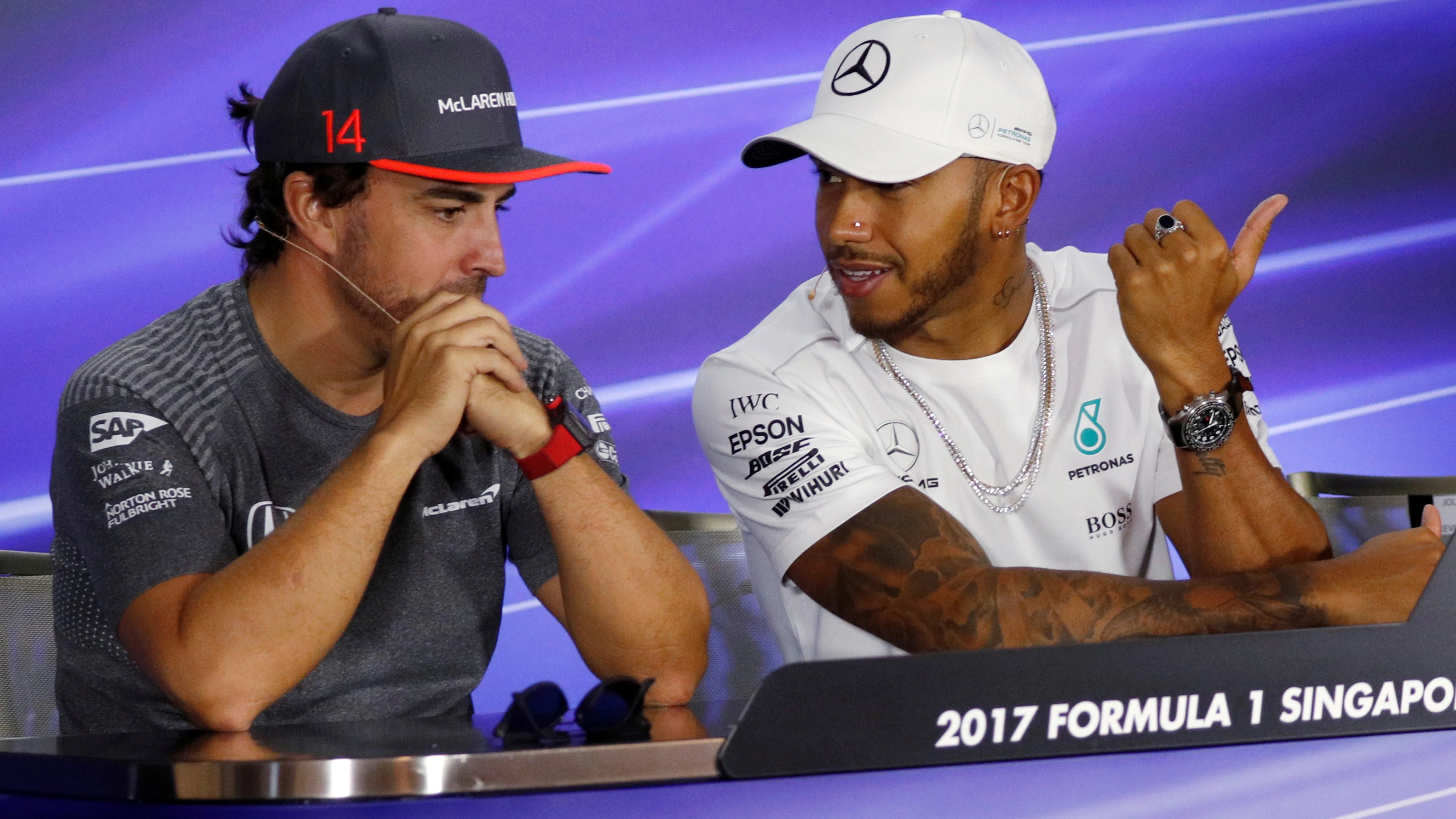 Fernando Alonso y Lews Hamilton dialogan durante el GP de Singapur