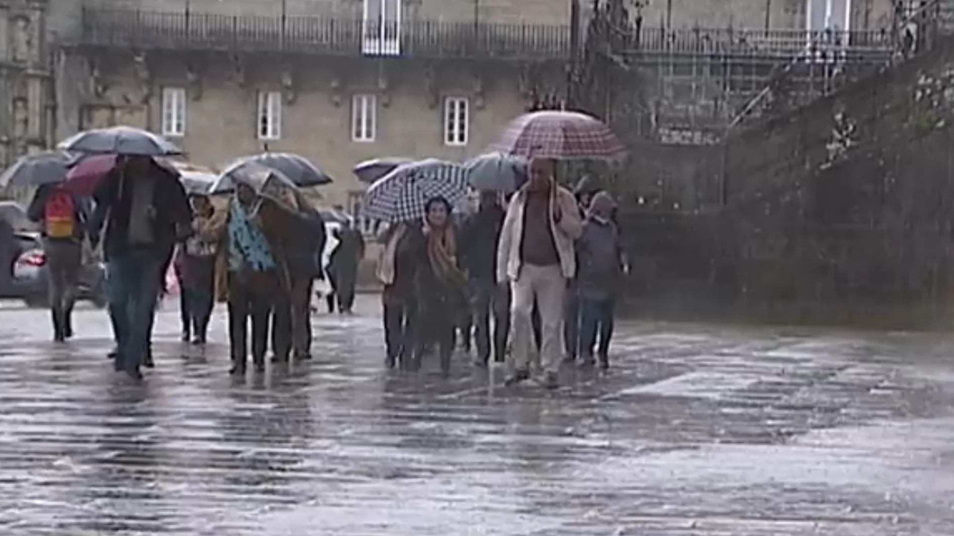Gente paseando en Santiago de Compostela lloviendo