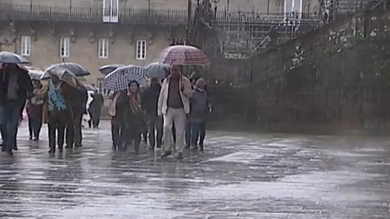 Gente paseando en Santiago de Compostela lloviendo