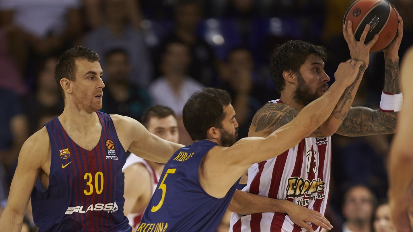 V&iacute;ctor Claver y Pau Ribas pelean por un bal&oacute;n con Georgios Printezis