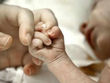 Un bebe coge de la mano a su madre Un bebe coge de la mano a su madre