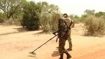 Dos hombres rastreando minas anti persona