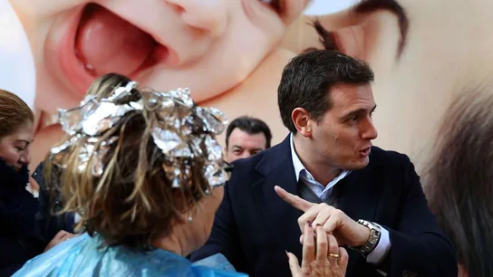 Una mujer sale de la peluquería con papel de plata en el pelo para saludar a Rivera Una mujer sale de la peluquería con papel de plata en el pelo para saludar a Rivera