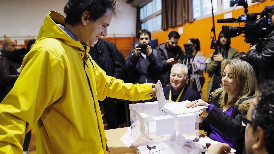 Un votante con un chubasquero amarillo