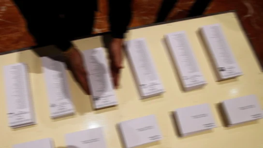 Una persona ordenando papeletas electorales Una persona ordenando papeletas electorales
