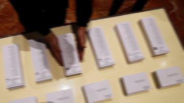 Una persona ordenando papeletas electorales