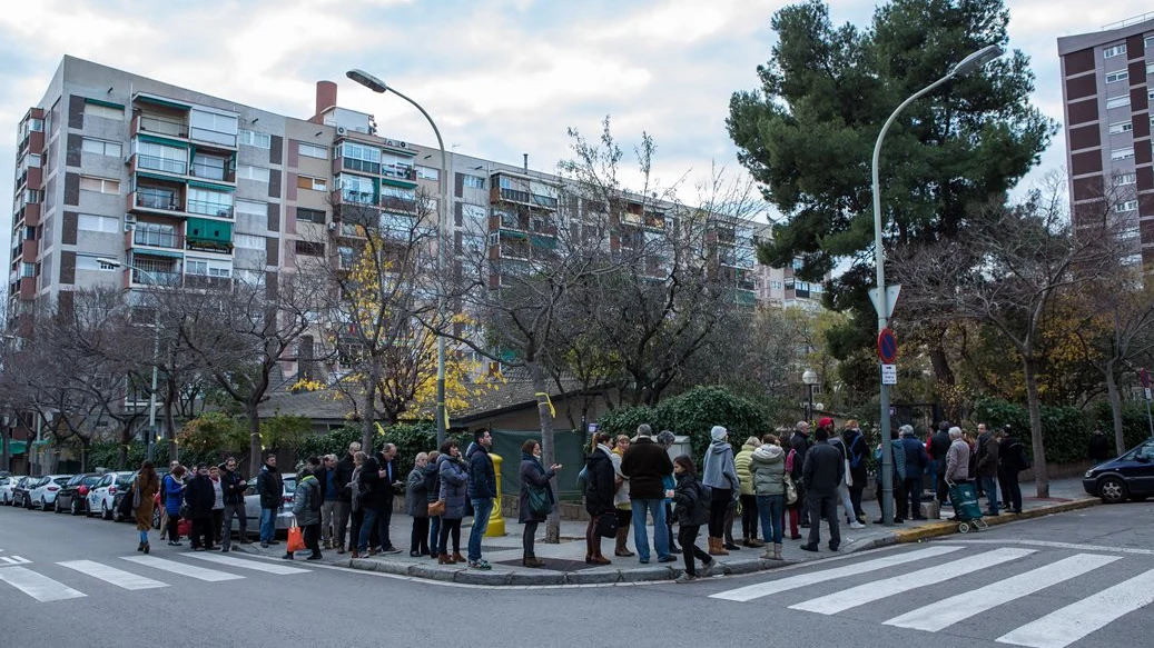 Personas esperando el momento de votar frente al colegio Narcís Monturió de Barcelona