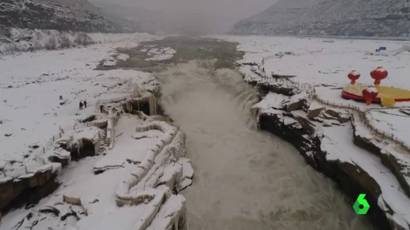 El fr&iacute;o y la nieve congelan y ti&ntilde;en de blanco parte de la cascada Hukou