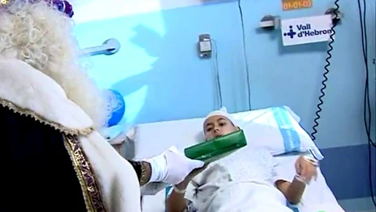 Un rey mago entrega un regalo a un niño en el hospital Un rey mago entrega un regalo a un niño en el hospital