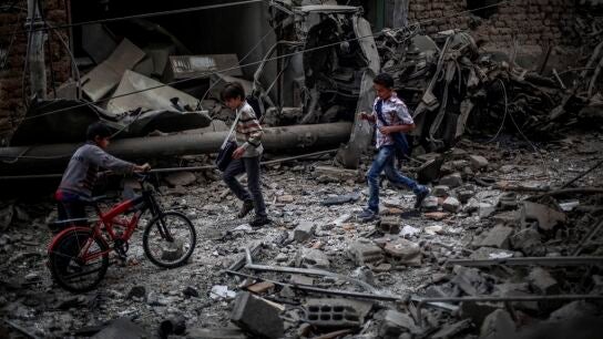 Ni&ntilde;os sirios observan los da&ntilde;os ocasionados tras un bombardeo a las afueras de Damasco