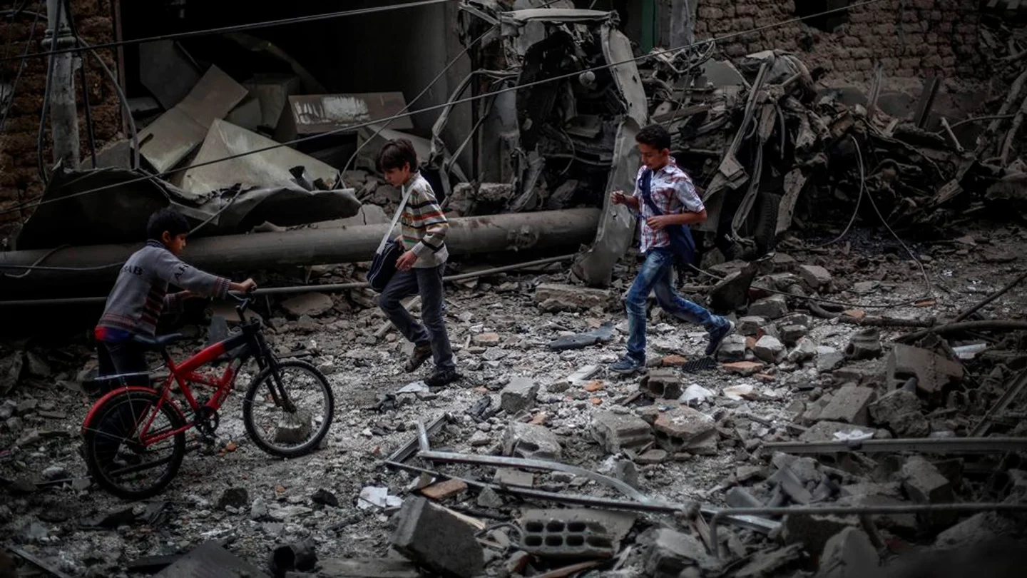 Niños sirios observan los daños ocasionados tras un bombardeo a las afueras de Damasco Niños sirios observan los daños ocasionados tras un bombardeo a las afueras de Damasco