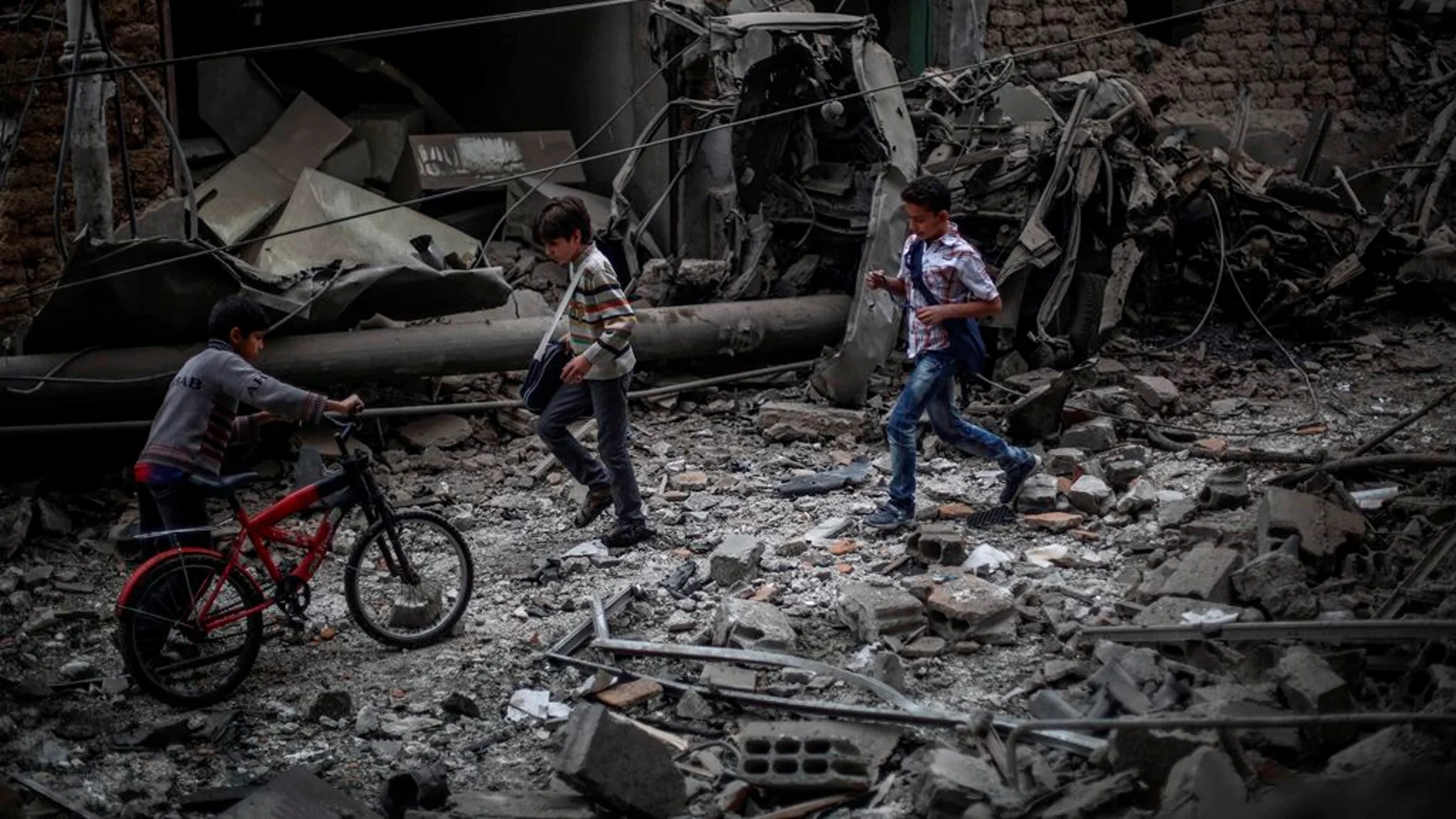 Niños sirios observan los daños ocasionados tras un bombardeo a las afueras de Damasco