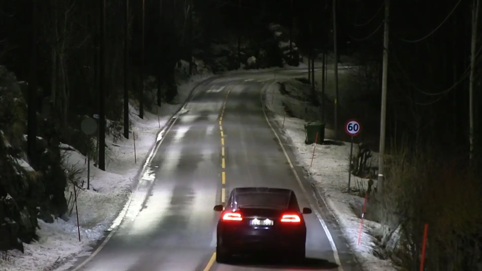 Los coches circulan por la carretera bajo la luz de las farolas inteligentes