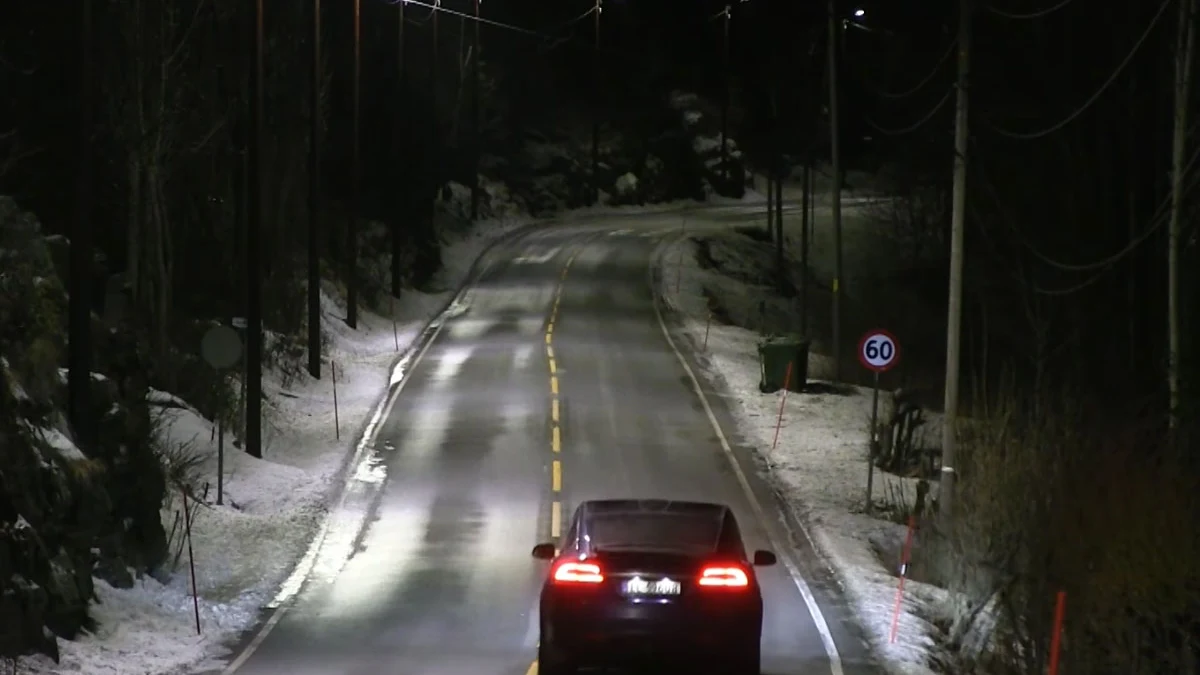 Los coches circulan por la carretera bajo la luz de las farolas inteligentes