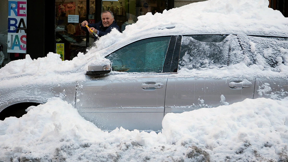 Un hombre retira la capa de nieve de un coche