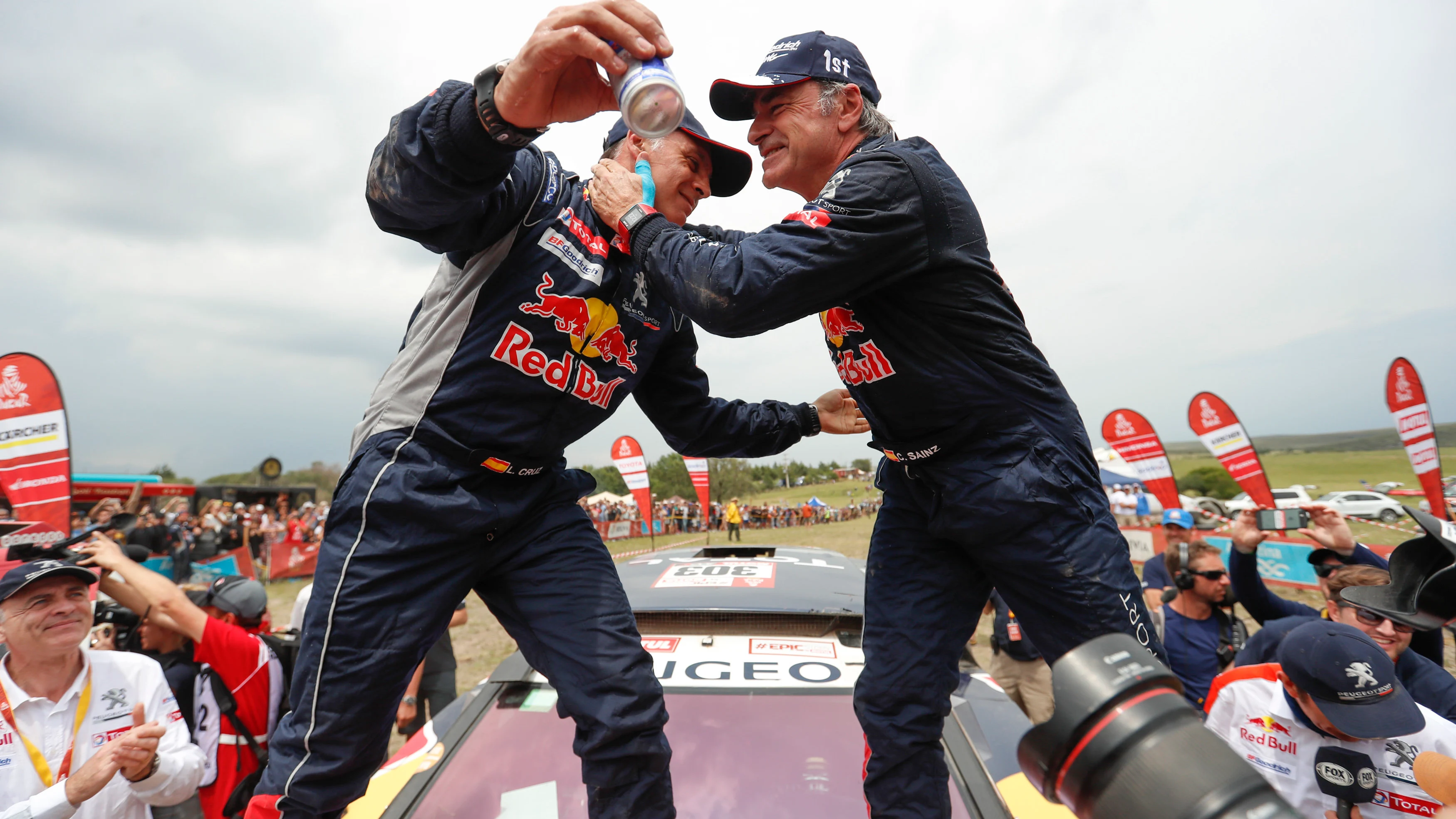 Lucas Cruz y Carlos Sainz se abrazan tras ganar el Dakar