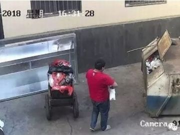 Una captura del momento en el que el padre arroja a su hija al contenedor Una captura del momento en el que el padre arroja a su hija al contenedor