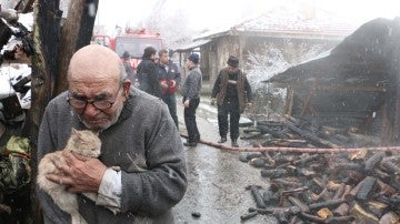 Un anciano abraza a su gato tras el incendio de su casa