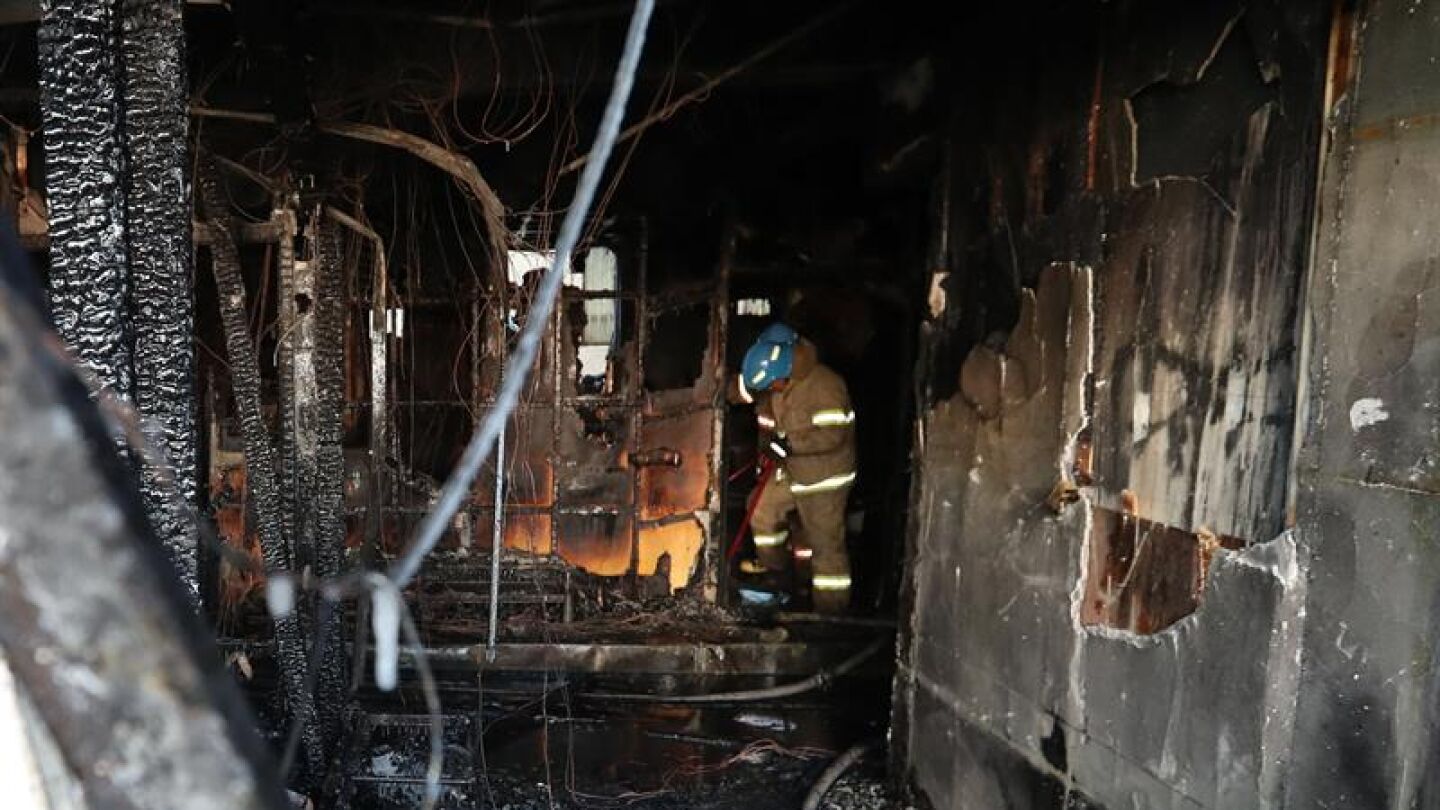 Bomberos apagan los restos del fuego en un cuarto de hospital Sejong