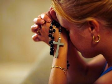 Mujer rezando en una iglesia Mujer rezando en una iglesia