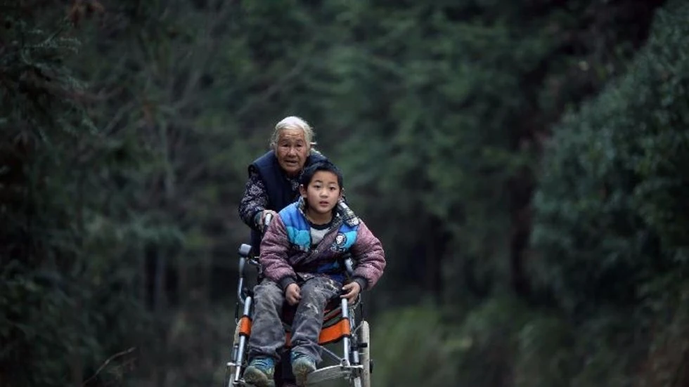 Shi Yuying y su nieto Haowen, atravesando la montaña para llegar al colegio