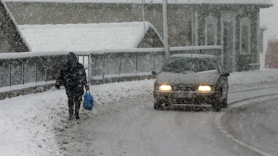 Una vecina del pueblo de Pajares camina entre la nieve Una vecina del pueblo de Pajares camina entre la nieve