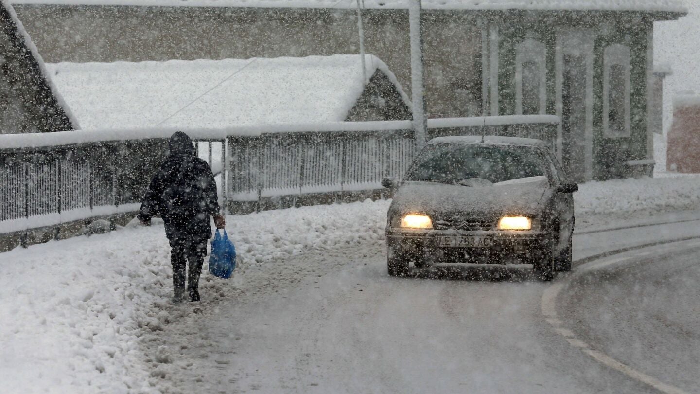 Una vecina del pueblo de Pajares camina entre la nieve