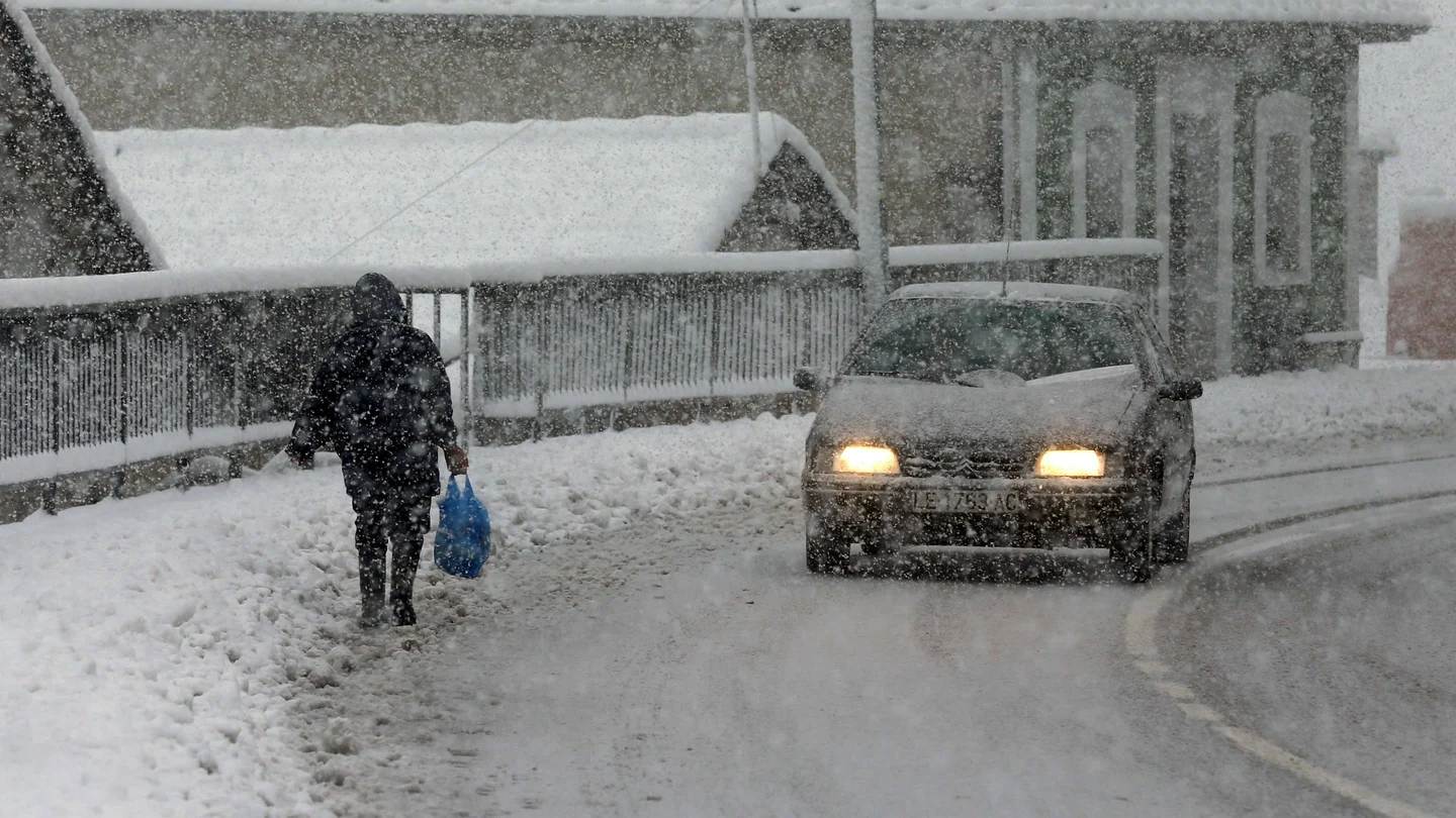 Una vecina del pueblo de Pajares camina entre la nieve Una vecina del pueblo de Pajares camina entre la nieve