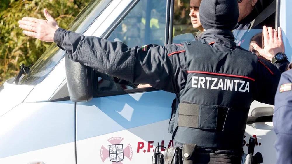 Un agente de la Ertzaina da instrucciones al personal de la funeraria 