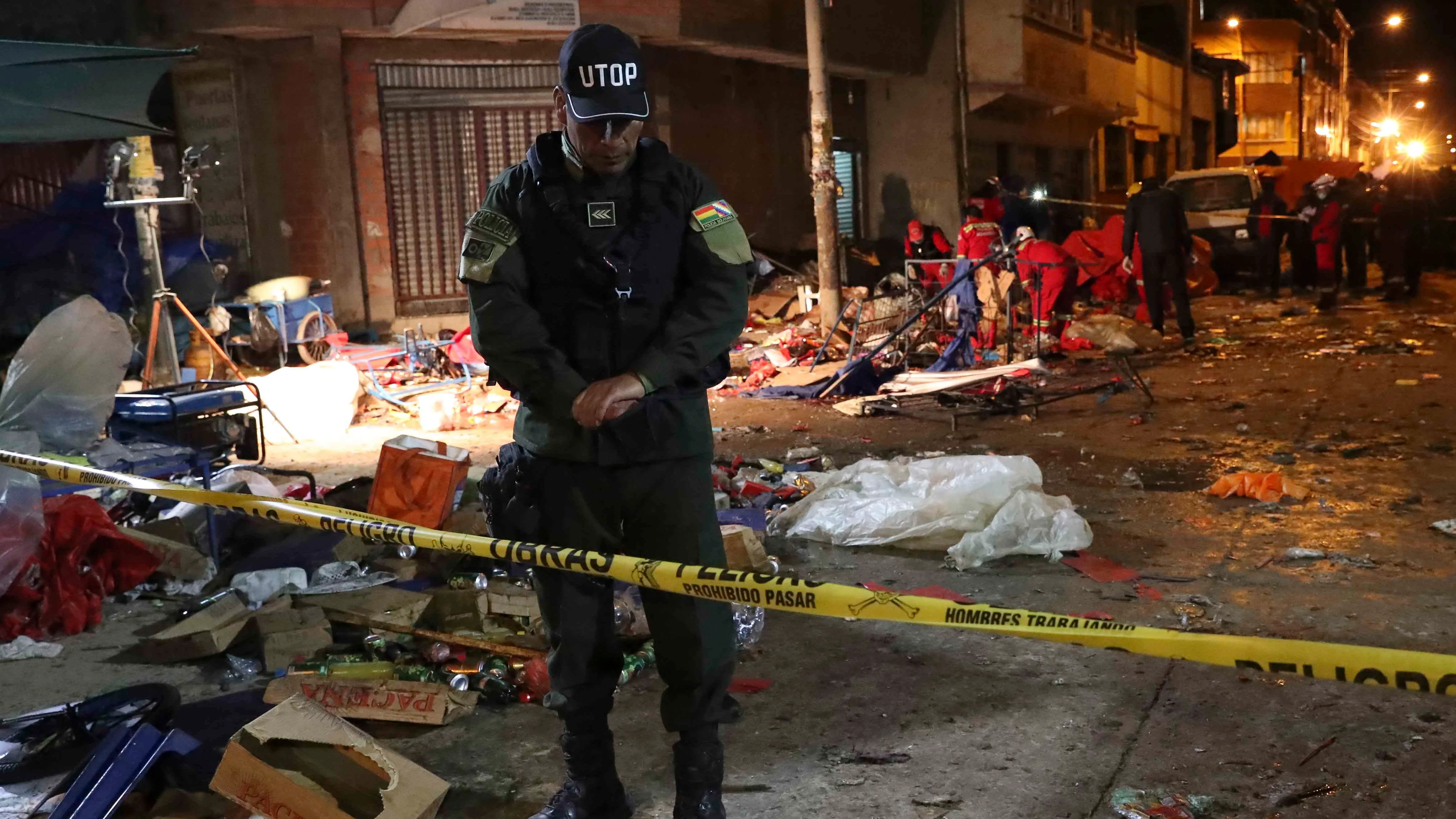 Una unidad de bomberos y miembros de la policía inspeccionan el lugar donde se produjo una explosión