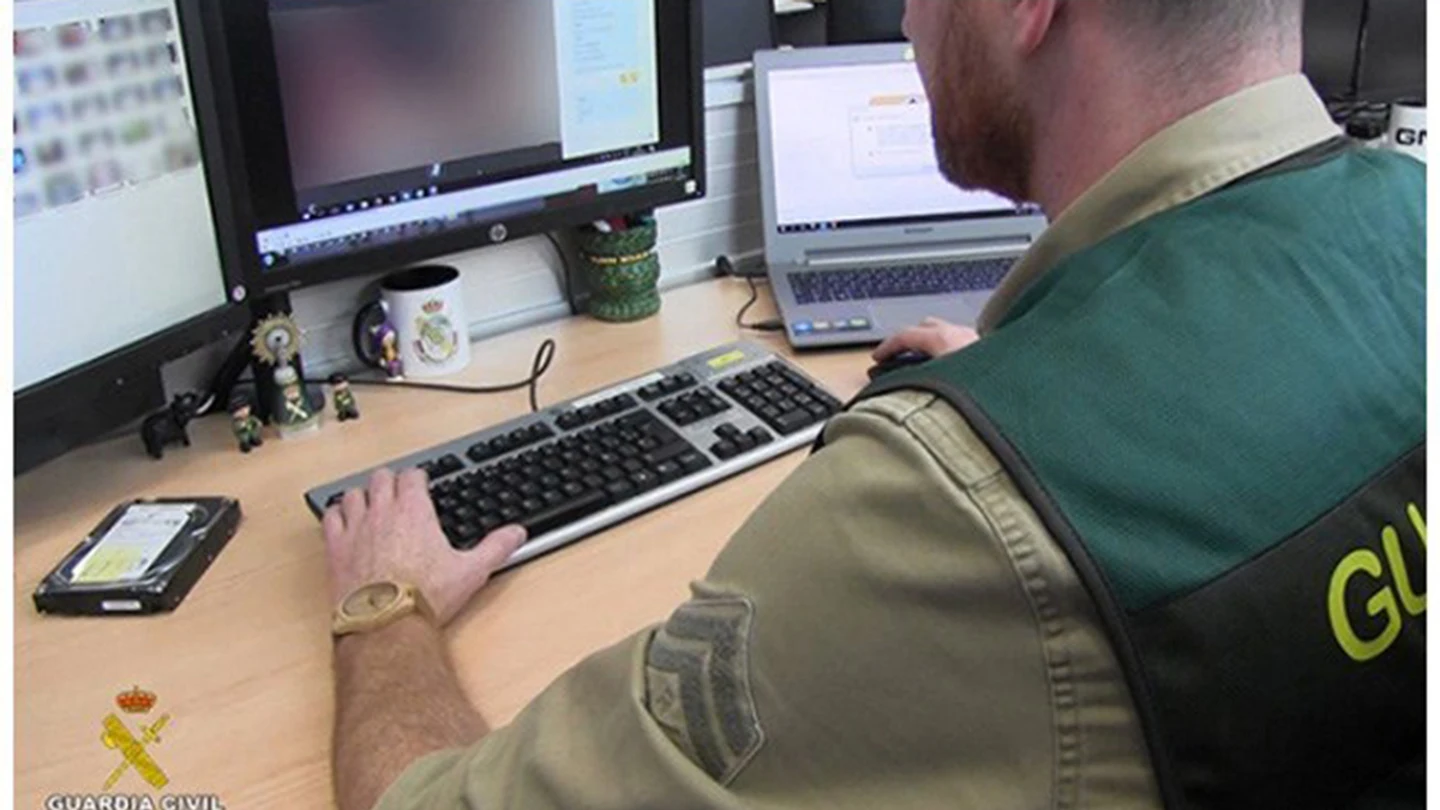Un agente de la Guardia Civil analizan las fotografías que tenía el depredador sexual detenido Un agente de la Guardia Civil analizan las fotografías que tenía el depredador sexual detenido