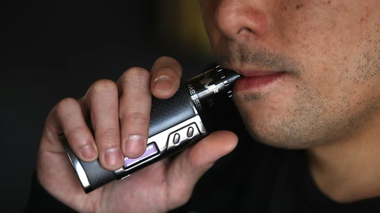 Un hombre fumando de un cigarro electrónico Un hombre fumando de un cigarro electrónico