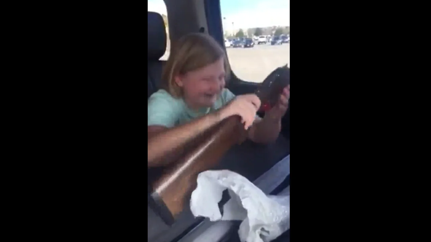 La niña en el momento de recibir el arma La niña en el momento de recibir el arma