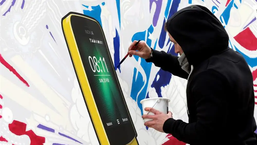 Un artista pinta el nuevo Nokia 8110 en el Mobile World Congress 2018