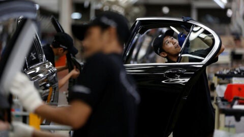 Workers put together doors for a locally assembled new BMW 7 Series on the production line at a Gaya Motor assembly plant in Jakarta