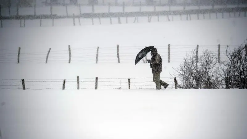 Un hombre camina entre la nieve