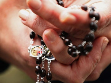 Una mujer con un rosario en las manos Una mujer con un rosario en las manos