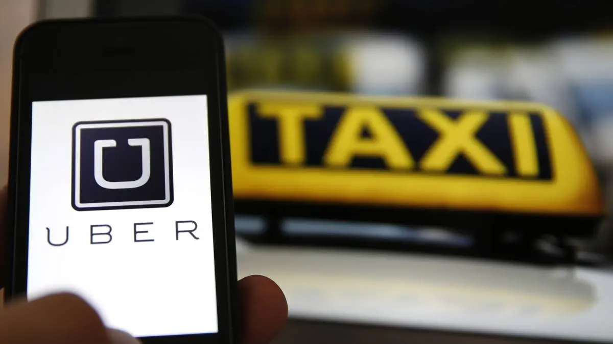 Imagende Uber y un taxi