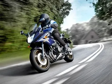 Una motocicleta circula por una carretera. Una motocicleta circula por una carretera.