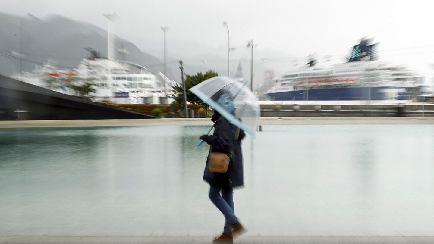 Una mujer paseando bajo la lluvia en Santa Cruz de Tenerife