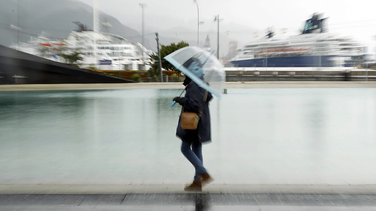 Una mujer paseando bajo la lluvia en Santa Cruz de Tenerife