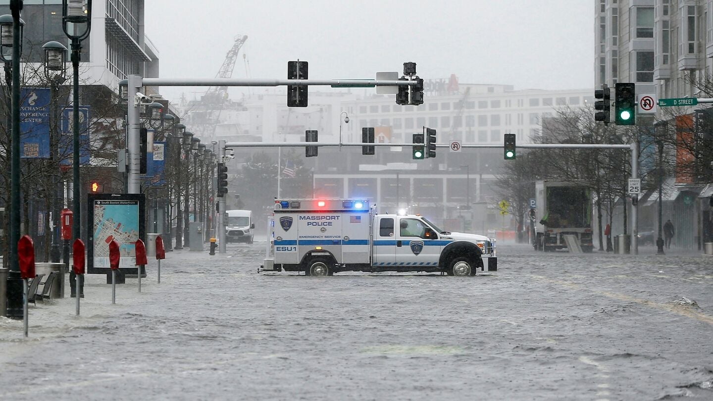Un coche de polic&iacute;a corta el tr&aacute;fico de la inundada Seaport Boulevard, durante una tormenta en el distrito Seaport de Boston, Massachusetts