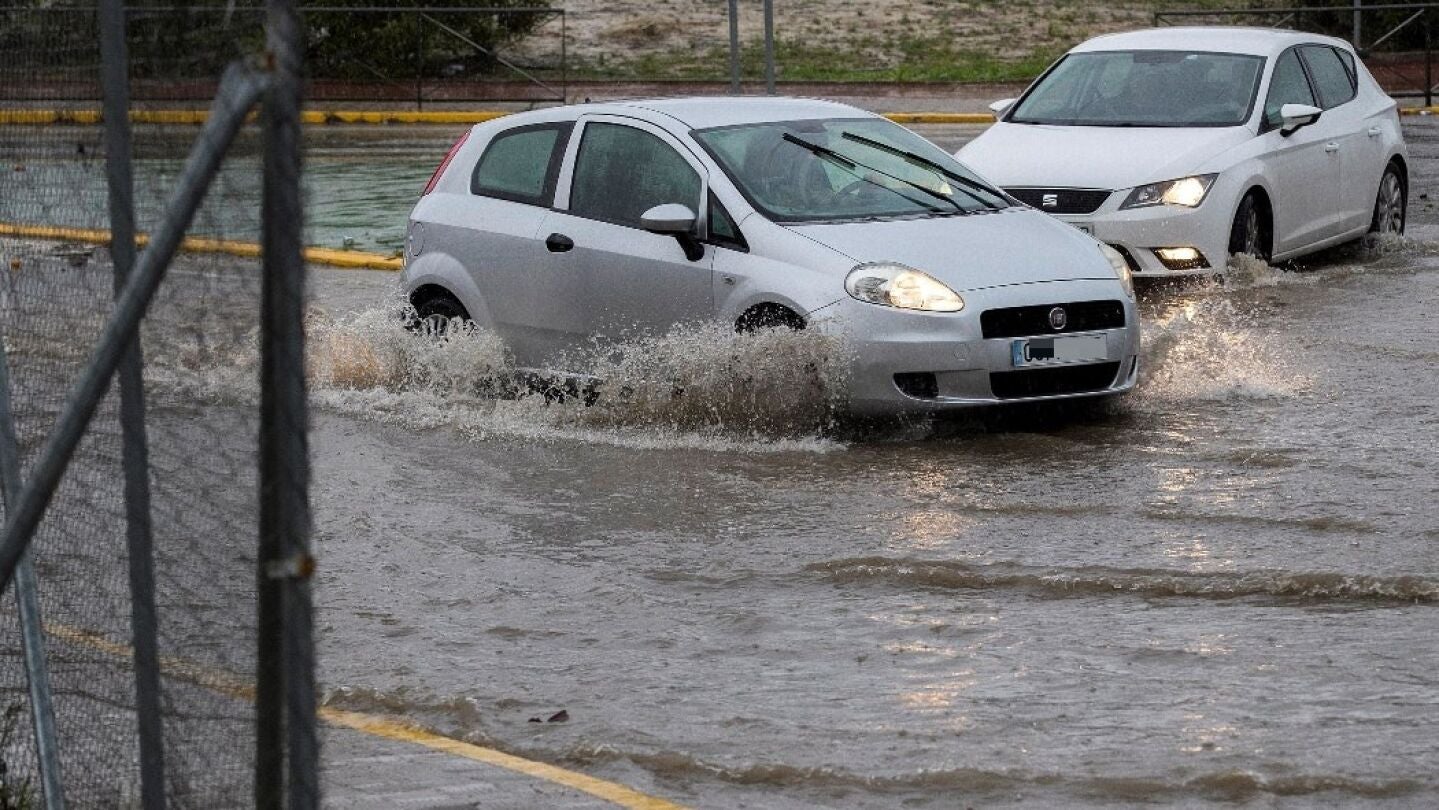 Veh&iacute;culos en una calle inundada en Sevilla