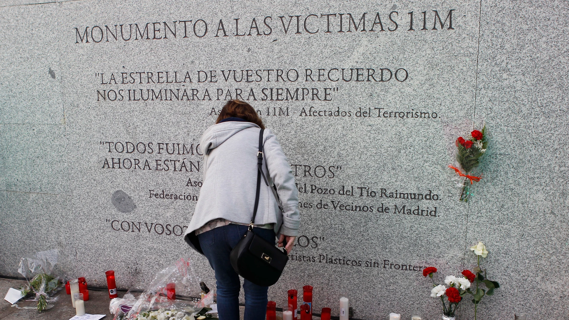 Flores y velas junto al monumento a las víctimas de los atentados del 11M, con motivo del decimocuarto aniversario de la masacre