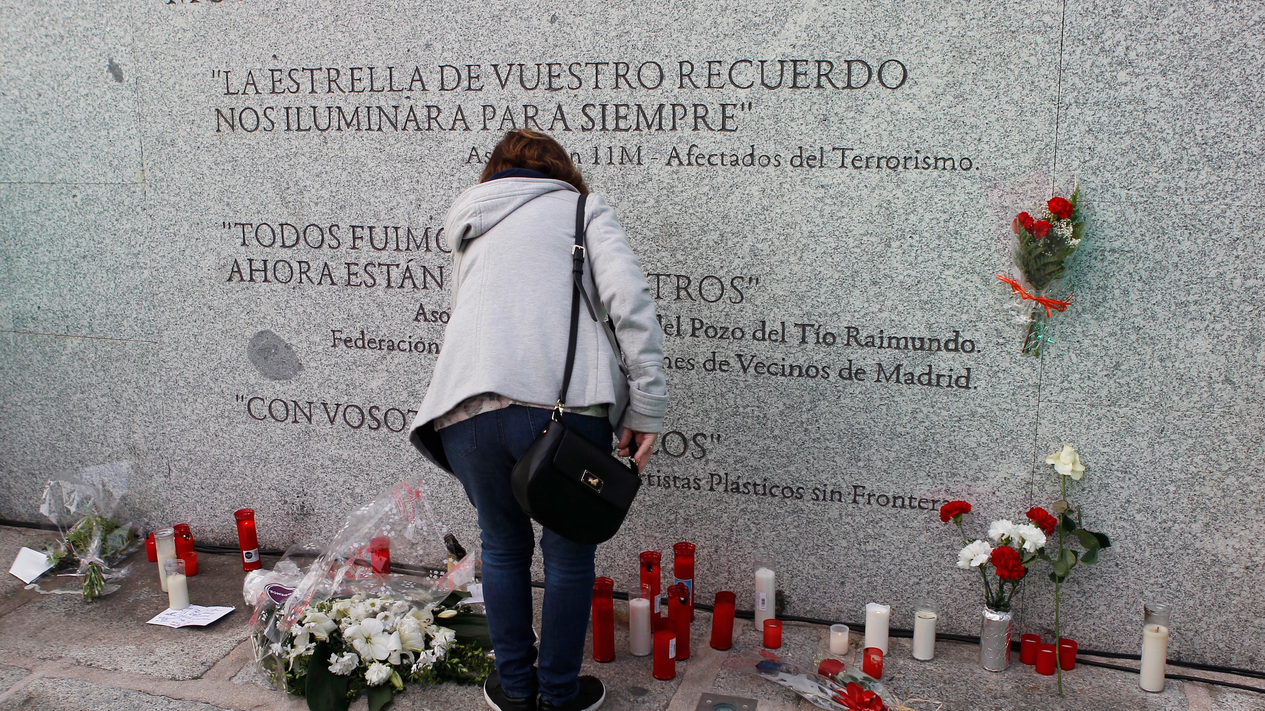 Flores y velas junto al monumento a las víctimas de los atentados del 11M, con motivo del decimocuarto aniversario de la masacre