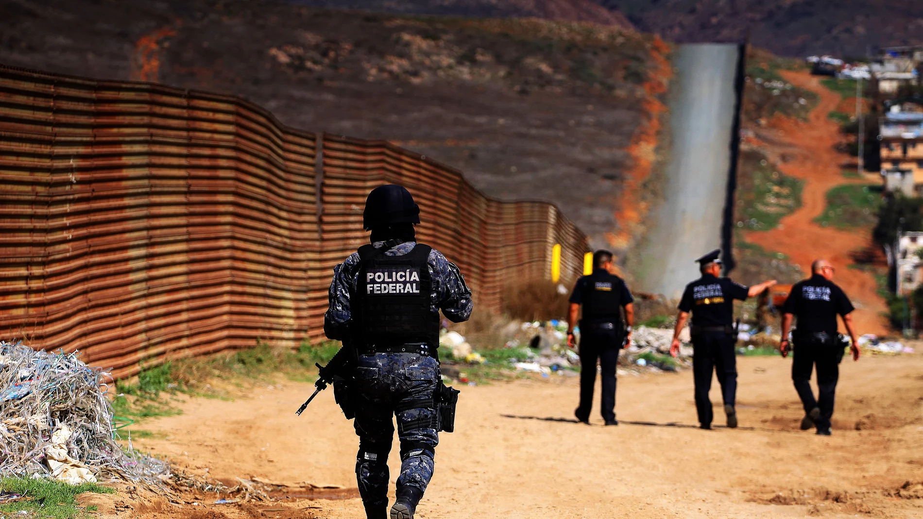 Policías federales custodian la barda fronteriza que delimita a México con territorio norteamericano