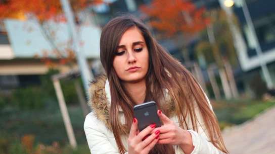 Una adolescente mira el móvil Una adolescente mira el móvil