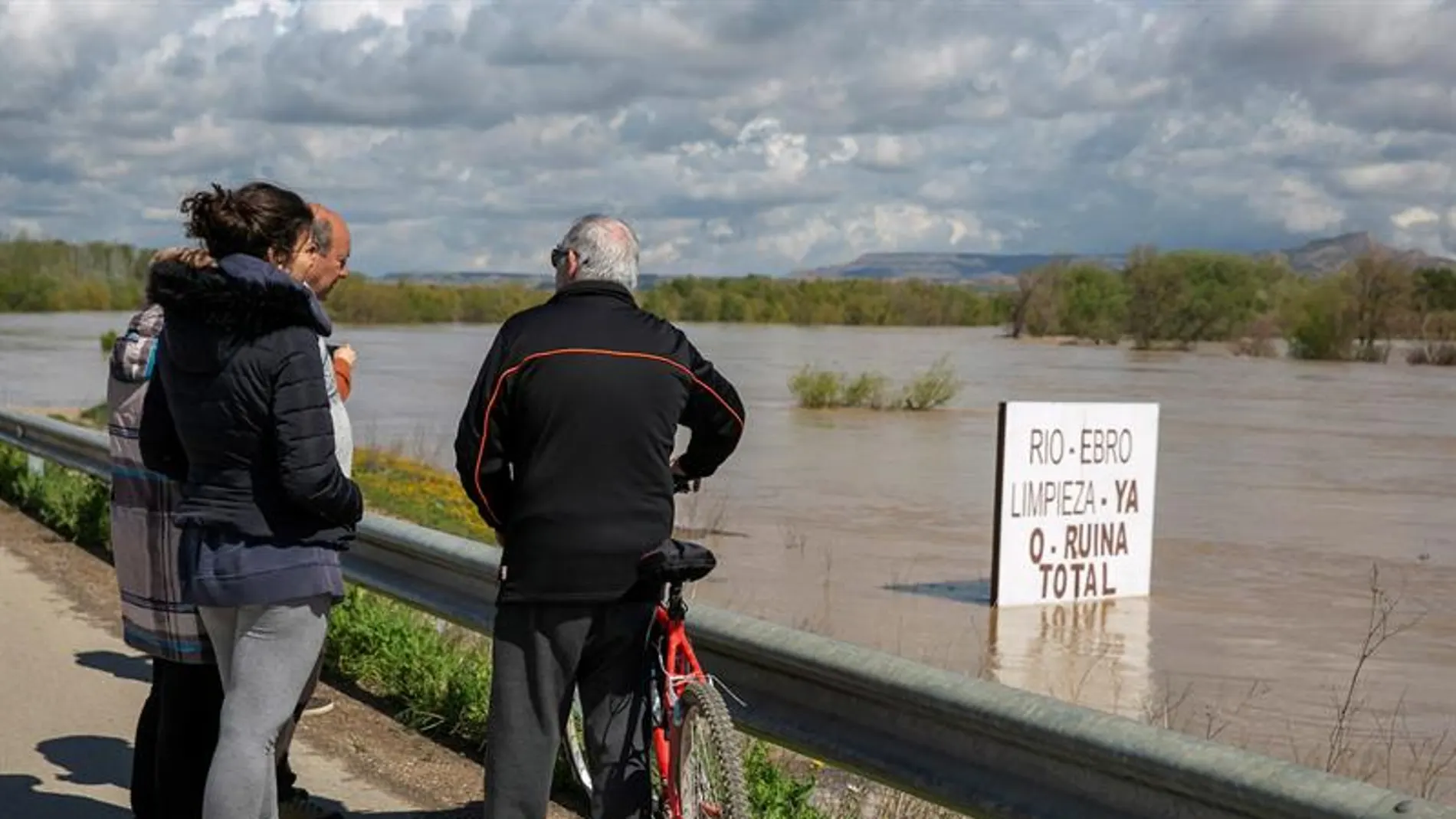  Unos vecinos contemplan el río Ebro, que se ha desbordado a sus paso por Novillas