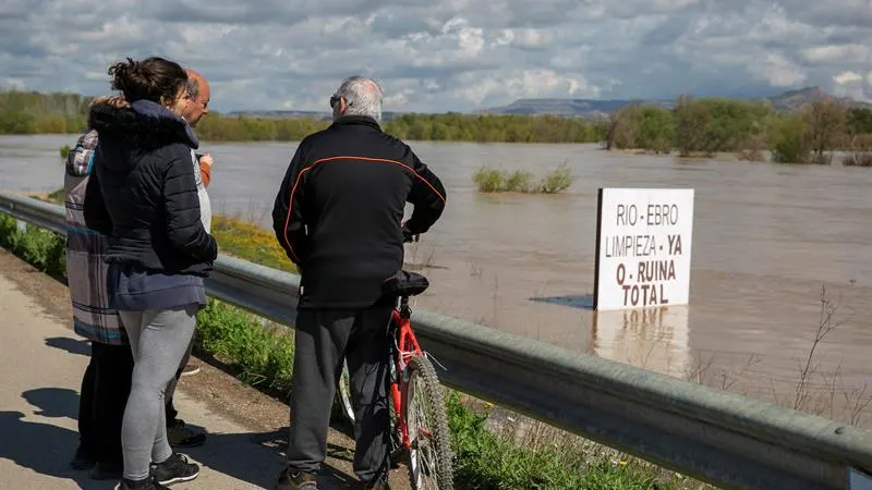  Unos vecinos contemplan el río Ebro, que se ha desbordado a sus paso por Novillas