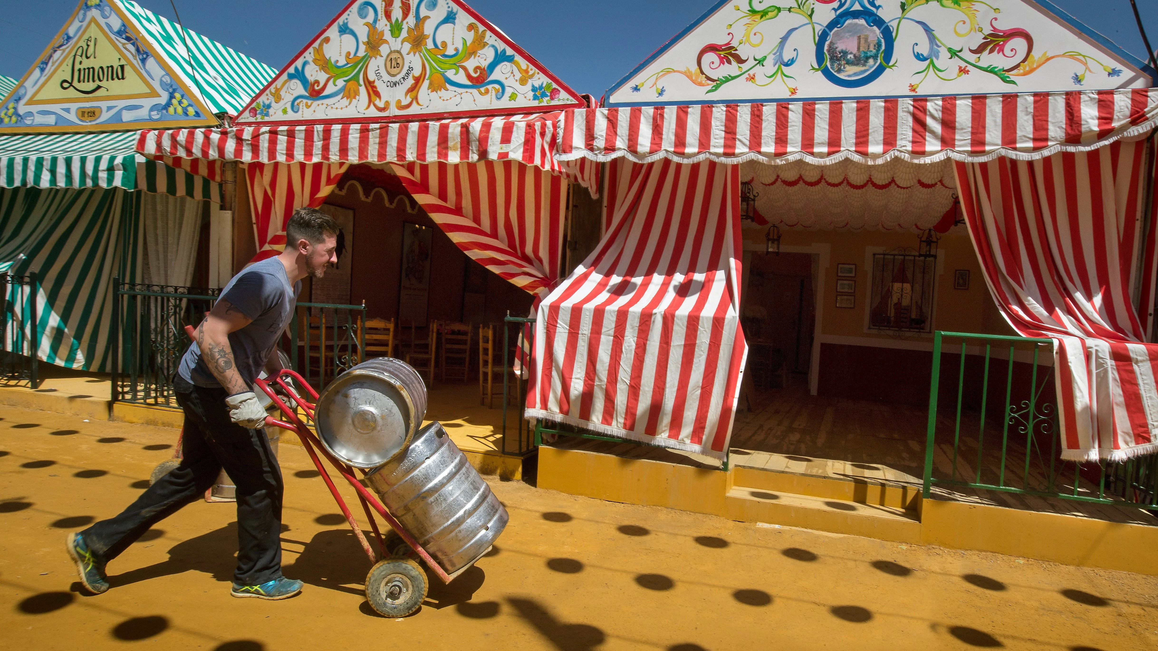 Un joven trabaja en los preparativos de la celebración de la Feria de Abril